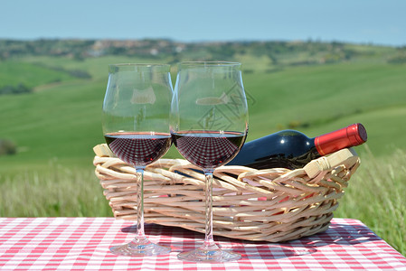 红葡萄酒在彩布上与托斯卡纳风景图片