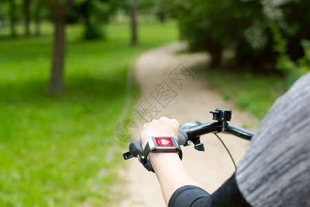骑自行车的女子配有智能观察心率监视器背景图片