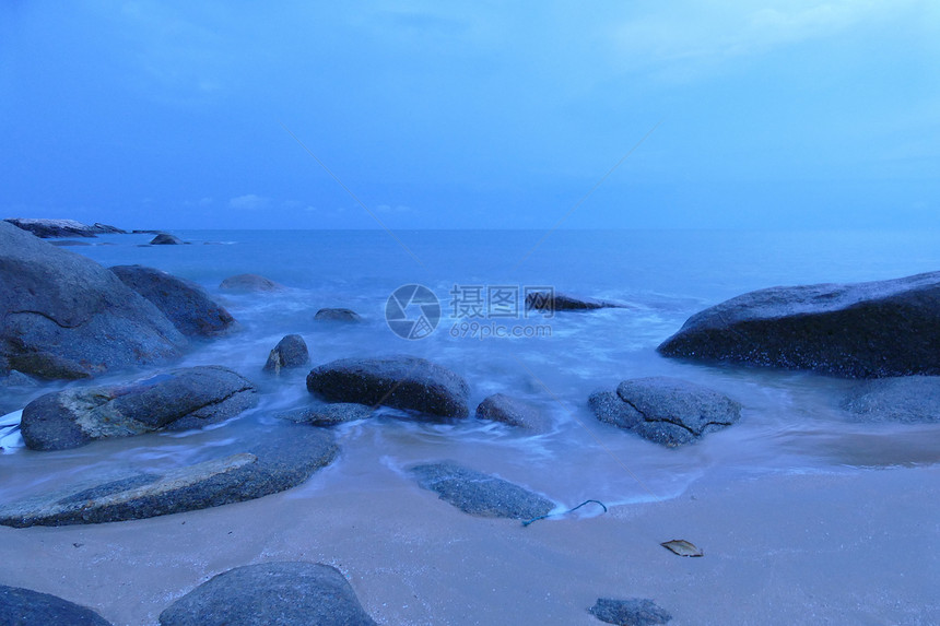 夜晚的海滩石头海浪和大海的景色图片