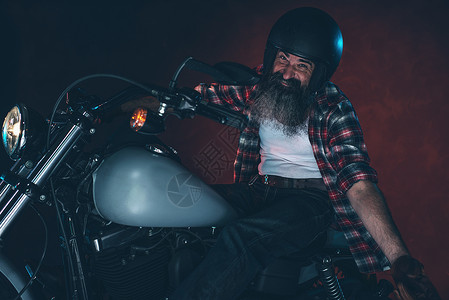 晚上骑着摩托车戴头盔的长胡子男图片