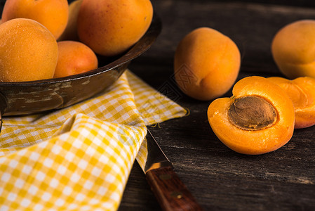 木制生锈桌上的新鲜有机杏子水图片