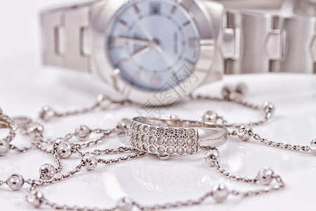 女士手表背景上的银戒指和链子图片