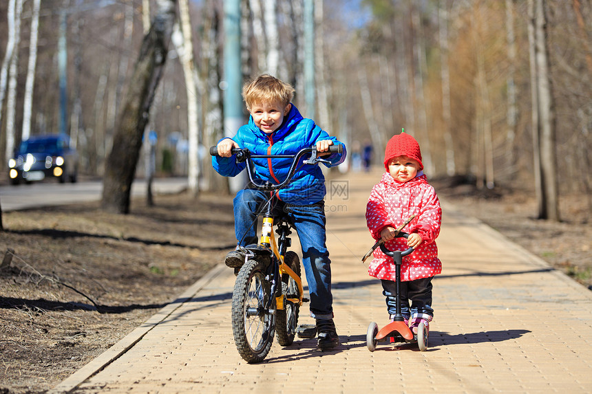男孩和幼儿女童兄弟姊妹在户外骑自图片