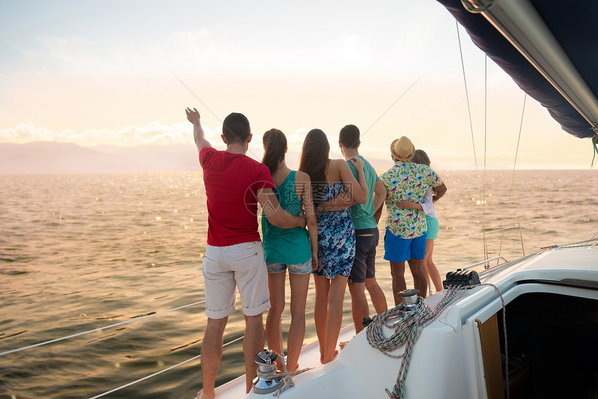 在帆船上度假在游艇上放松的恩爱夫妻男孩和女孩在帆船上进行海上航行年轻人在日落时在游艇上度过一个周末图片