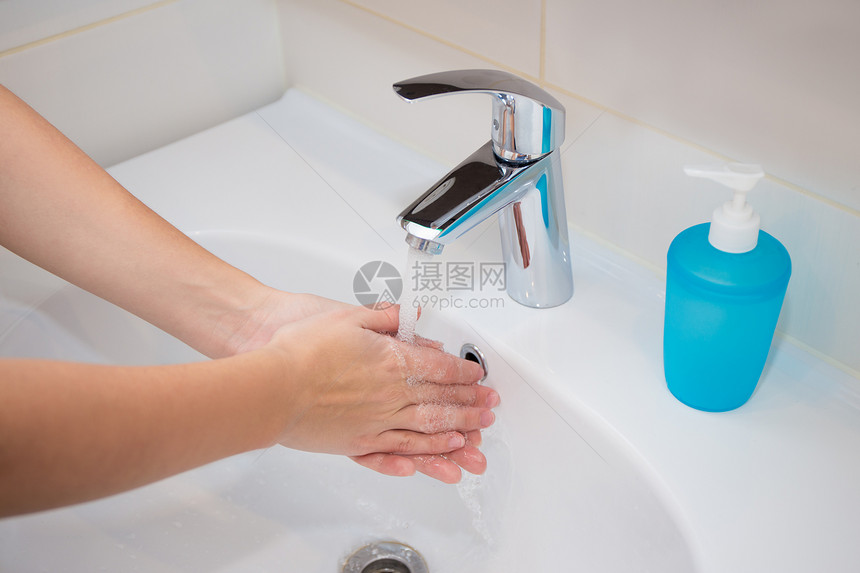 女人在浴室里用肥皂洗手图片