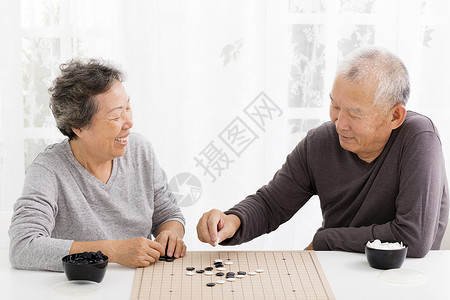 快乐的亚洲老夫妇在客厅下棋图片