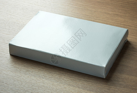 深色木质背景上的空白灰色纸盒图片