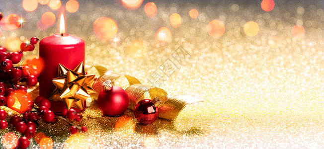 金色装饰品上的红色圣诞蜡烛图片