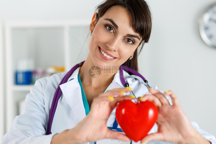 美丽微笑的女医生在胸部特写前拿着红色的心医疗帮助预防保险手术和复苏概念心脏病学护理健康图片