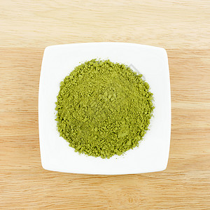 木板上的迷你白盘子上的日本抹茶绿粉背景图片