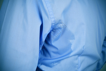 一个穿着蓝色衬衫身上有下臂汗渍的高清图片