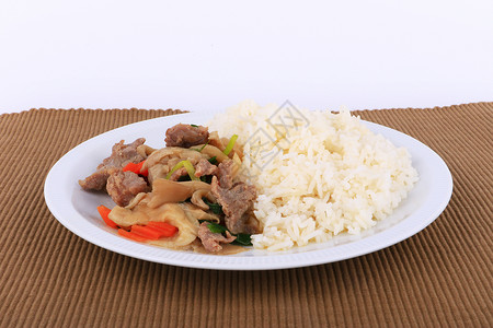 白盘上的蚝油米饭和炒牛肉隔离图片
