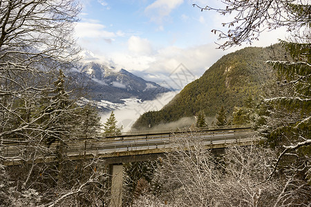 在雪寒冬高山风景中穿过树顶的气流图片