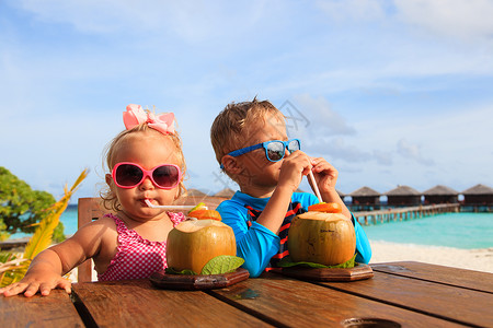 在热带海滩度假胜地喝椰子鸡尾酒孩子们奢华旅行的幼小男图片
