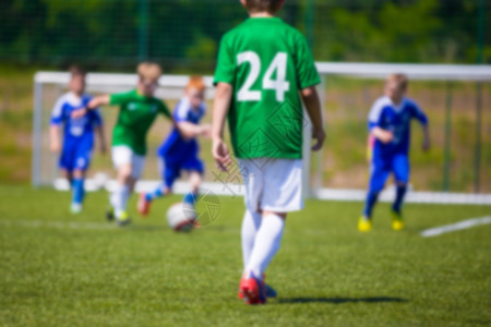 运动足球背景模糊踢足球比赛的小男孩蓝队和绿队之图片