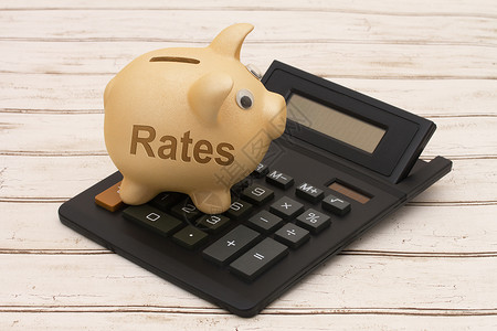 储蓄利率金猪银行和含文字的木本背景计算器利息率图片