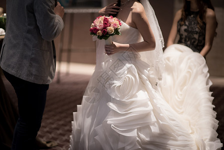 漂亮的婚纱展示了新娘拿着花束的礼服细节图片