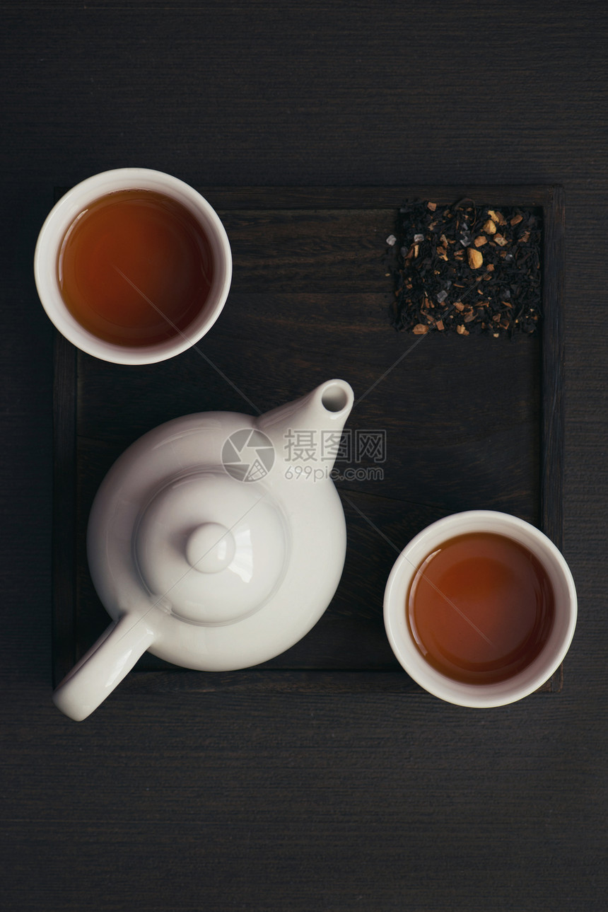 深色木盘上的茶杯和茶壶图片