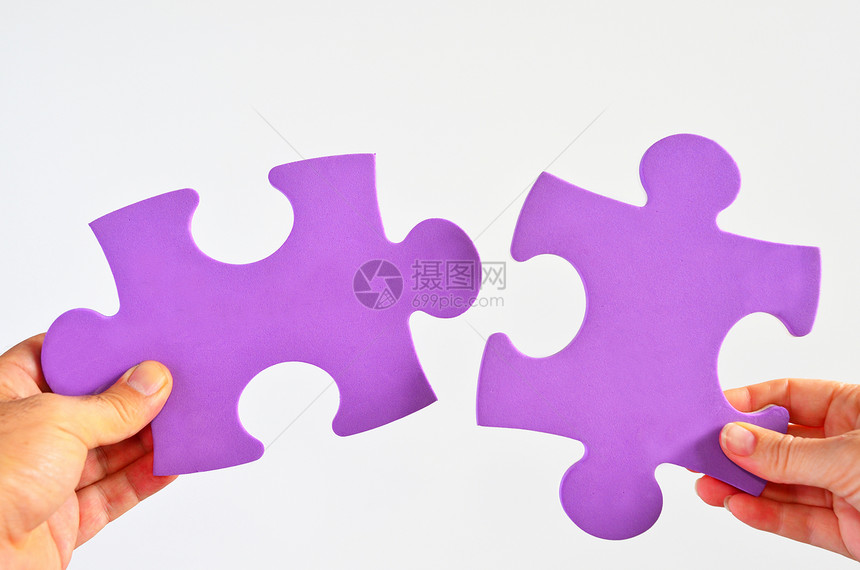 男人和女人的手握着两个不同的拼图图片