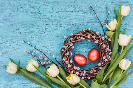 蓝背景的复活柳花复活鸡蛋和白色郁金香顶视图片
