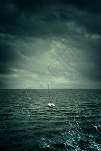 一艘小帆船漂浮在动荡的水域和暴风图片