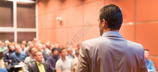在商务会议上发表公开演讲的演讲者会议厅的观众商业和理念背景图片