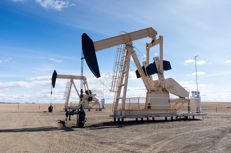一对抽油机从加拿大艾伯塔省农村的一口地下井中提取石油这些千斤顶每次冲程可提取5至40升原背景图片