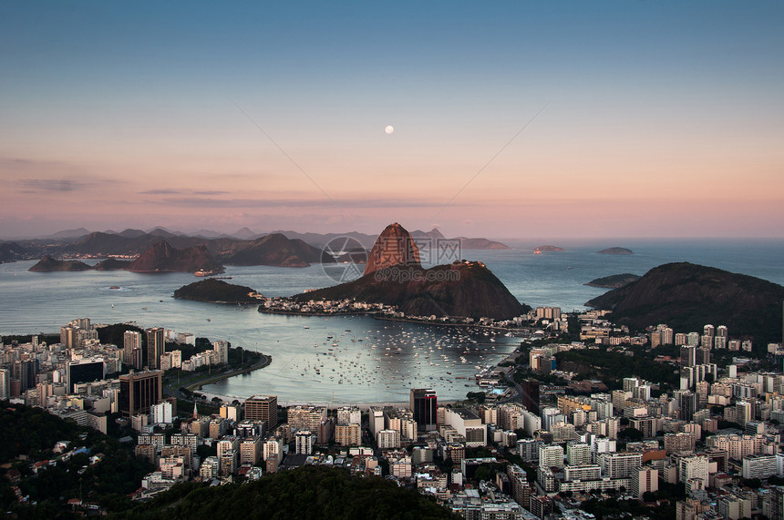 里约热内卢天线与糖浆山和船只在晚图片