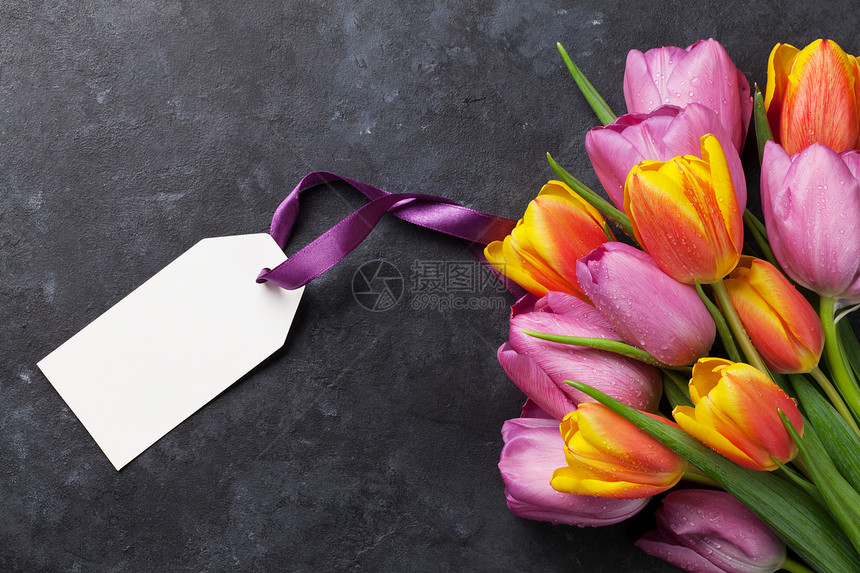 在深石桌上贴标签的新鲜彩色郁金花朵带有复制图片