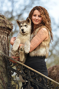 年轻女子与她的狗Alaskan马图片
