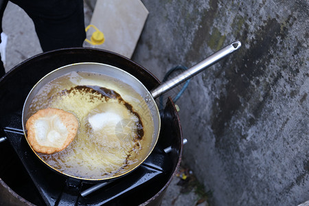 用沸腾的热油准备煎饼的大铝锅图片