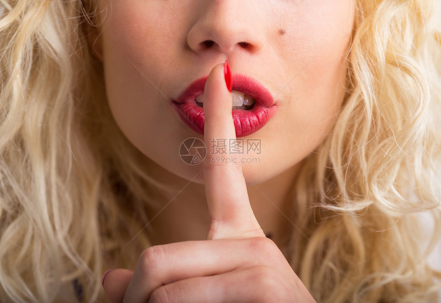 女人握着她的手指压在她的嘴唇上图片