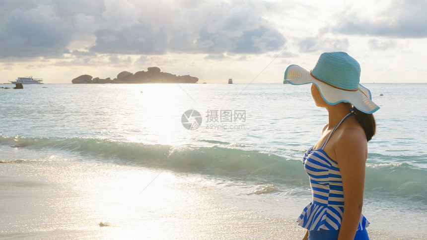 身戴帽子和泳装的年轻女孩在泰国PhangNga岛Similalan群岛公园KohMiang的蜜月湾海滩日出时图片