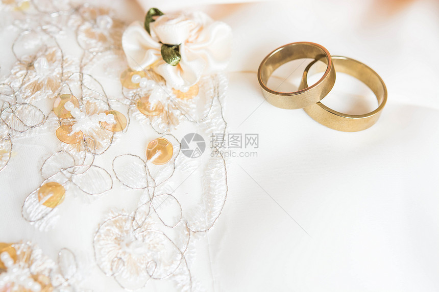 放在婚纱上的两个结婚戒指图片