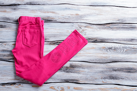 亮粉色休闲裤木制背景上的粉红色裤子女孩全新的裤子优质面料图片
