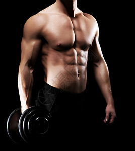 强壮健康和运动型健美男子在黑色背景下用哑图片