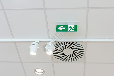 标准国际标志安全出口标志悬挂在现代办公天花板顶上图片
