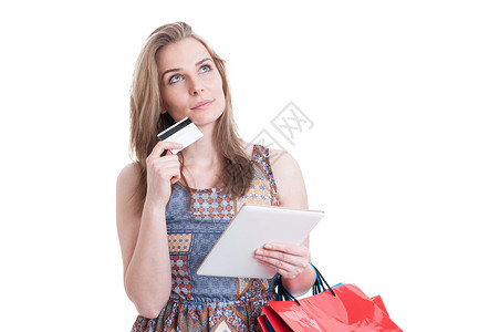 带着信用卡和现代平板电脑思考买什么作为互联网购物概念的粉丝花丽淑女图片
