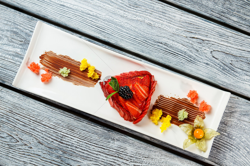 草莓片上的黑莓盘子上的装饰甜点美食家的甜点草莓果馅饼图片
