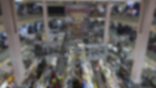 在当地杂货市场摊位上销售和购买食品及布料的人模糊图片