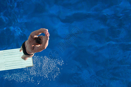 男潜水员在潜水前在跳板上弹跳图片