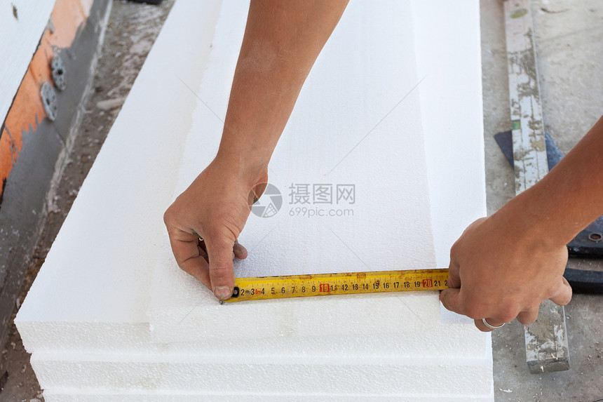 用泡沫塑料板隔热的房子基础墙工人用尺子测量泡沫塑图片