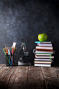 笔记本用品和苹果放在粉笔板前返回学校概图片
