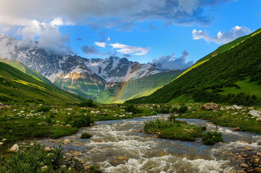 快速的河流和雪峰高山上的彩虹阳图片