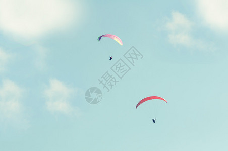 双滑翔机在太阳光和白云下飞上天空并有图片