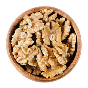 核桃仁一半在一个木碗在白色背景普通核桃Juglansregia的棕色干燥种子可食用有机和纯素食品孤立的宏观照背景图片