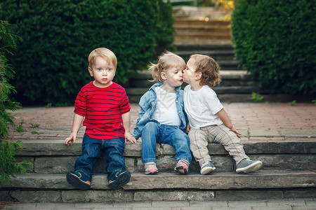 三组可爱风趣可爱的白人儿童蹒跚学步的男孩女坐在一起亲吻图片