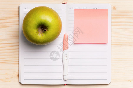 对空白打开书的新消息进行妊娠测试白纸和青苹果在一张木图片