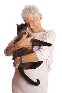 快乐的成熟女人在她的怀里抱着尖锐的猫在图片