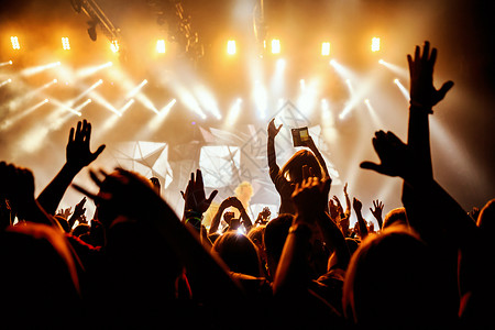 在明亮的舞台灯前人们在摇滚音乐会人群中图片